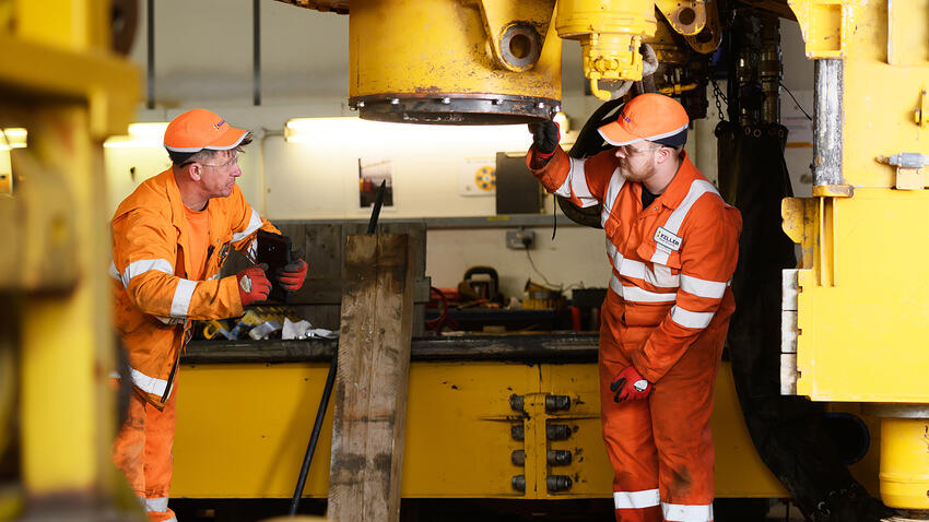 Apprentice with colleague maintaining a rig