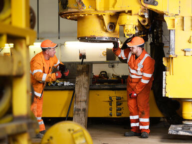 Apprentice with colleague maintaining a rig