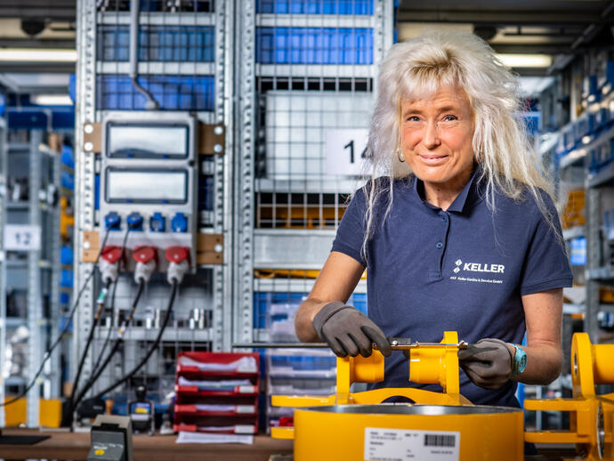 Eine Mechanikerin kontrolliert die Maße eines Bauteils. Sie arbeitet in der Qualitätssicherung.